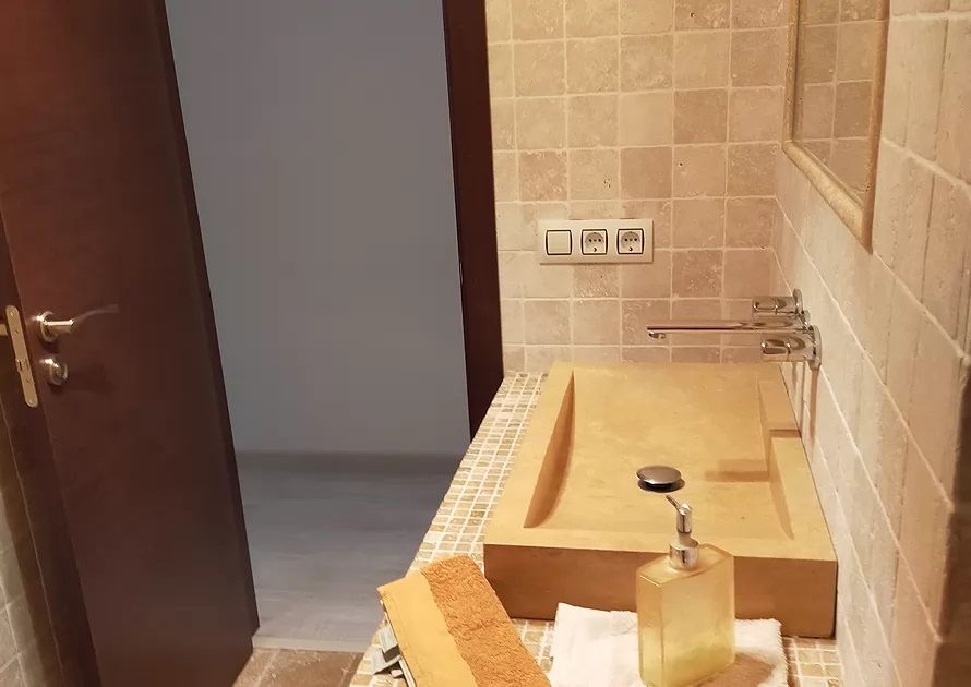 Entrada al aseo de mármol travertino en Villa Sanabria